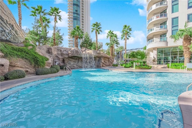 view of swimming pool with pool water feature