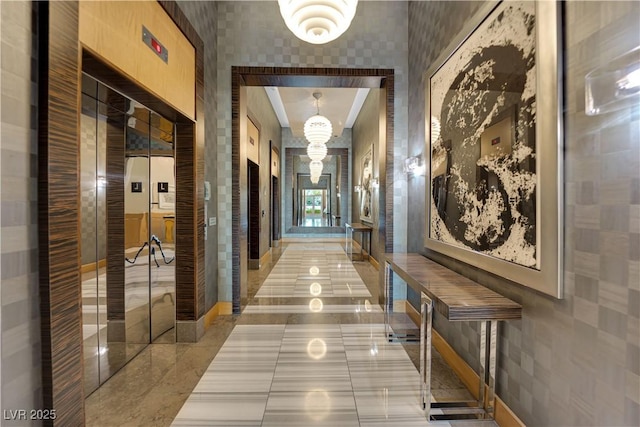 hallway featuring elevator and a high ceiling