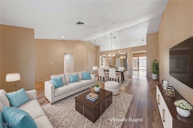 living room featuring lofted ceiling and light wood-type flooring