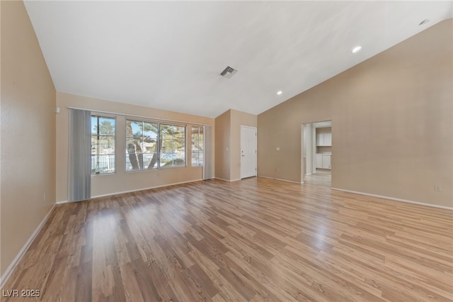 unfurnished living room with high vaulted ceiling and light hardwood / wood-style flooring