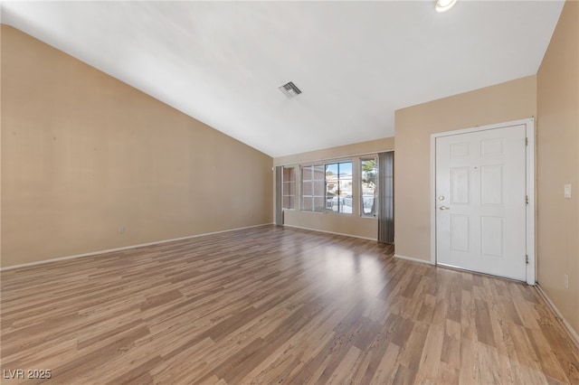 unfurnished living room featuring lofted ceiling and light wood-type flooring