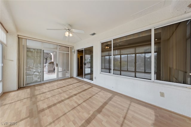 unfurnished sunroom featuring ceiling fan