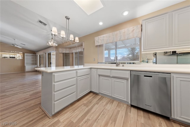 kitchen with dishwasher, lofted ceiling, sink, and white cabinets