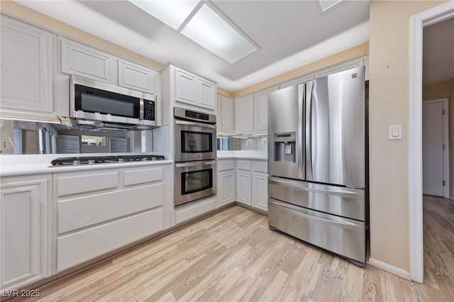 kitchen with white cabinetry, light hardwood / wood-style flooring, and stainless steel appliances