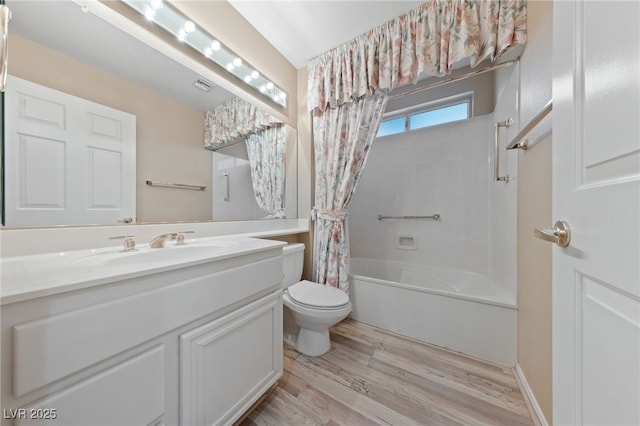 full bathroom with hardwood / wood-style flooring, vanity, shower / bath combo with shower curtain, and toilet