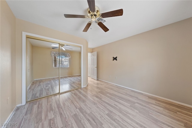 unfurnished bedroom featuring light hardwood / wood-style flooring, a closet, and ceiling fan