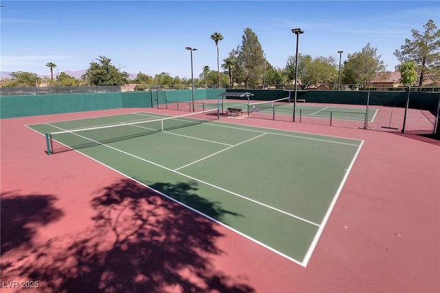 view of tennis court featuring basketball hoop