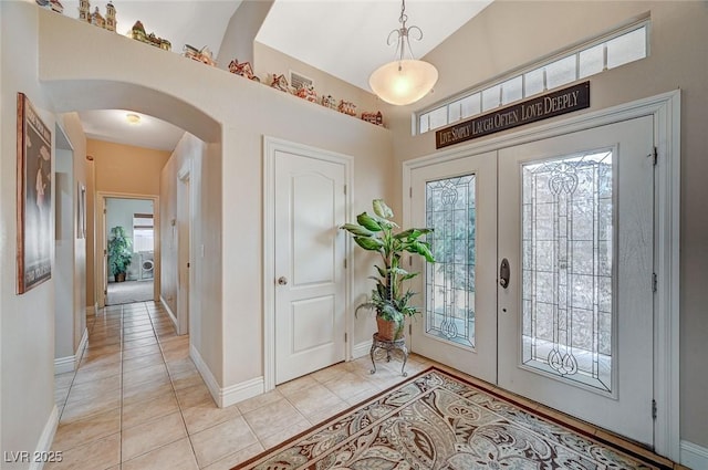 tiled entrance foyer with high vaulted ceiling and french doors