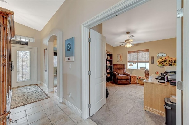 entryway featuring lofted ceiling, light tile patterned floors, and ceiling fan