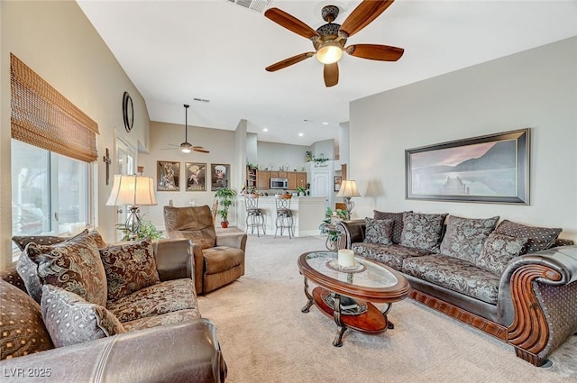 carpeted living room featuring ceiling fan