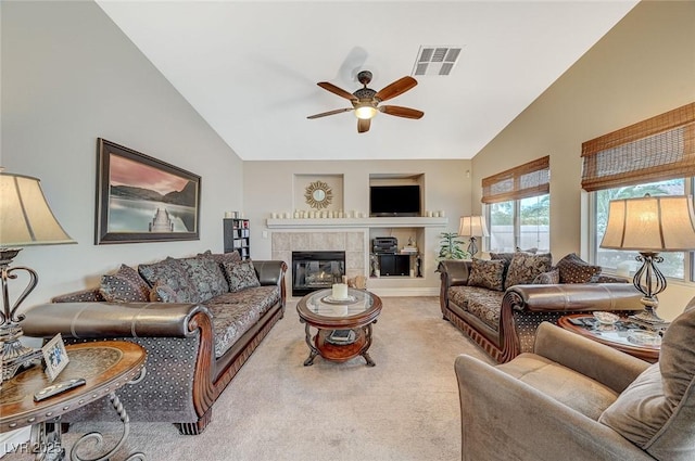 living room with ceiling fan, light colored carpet, a fireplace, and high vaulted ceiling