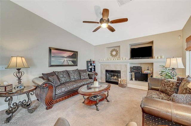 living room with lofted ceiling, a tiled fireplace, light colored carpet, and ceiling fan