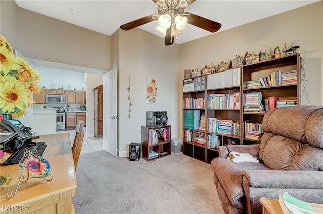 living area with light carpet and ceiling fan