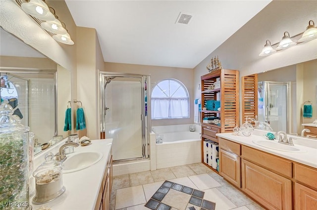 bathroom featuring tile patterned flooring, vanity, vaulted ceiling, and separate shower and tub