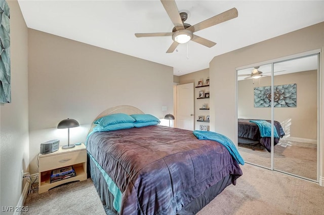 bedroom featuring ceiling fan, light colored carpet, a closet, and a baseboard heating unit