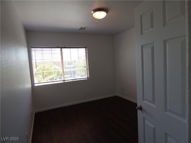 spare room featuring dark wood-type flooring