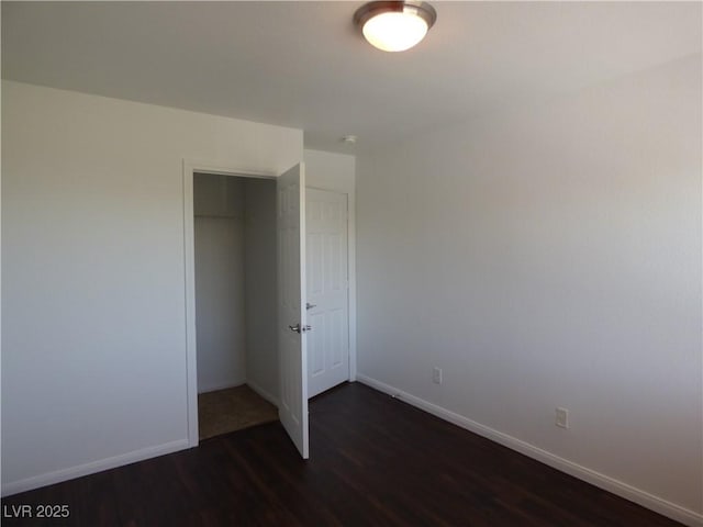 unfurnished bedroom with dark hardwood / wood-style flooring and a closet