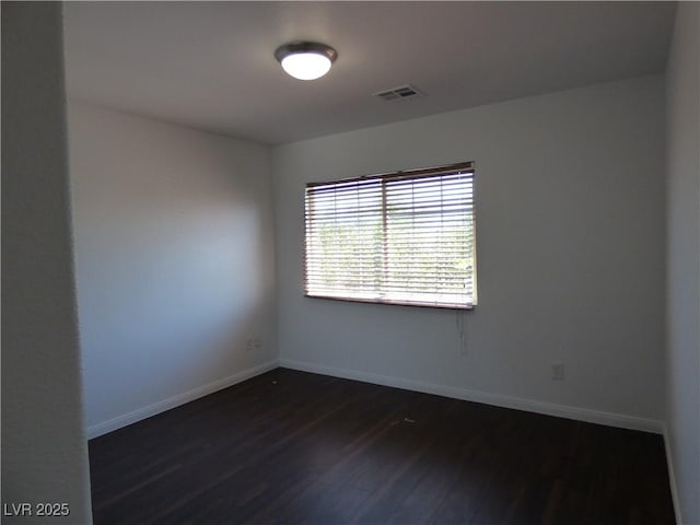 spare room with dark hardwood / wood-style floors