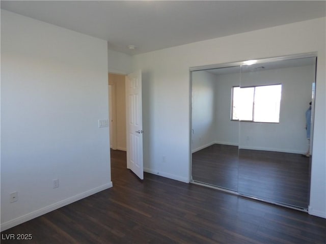 unfurnished bedroom with a closet and dark hardwood / wood-style floors