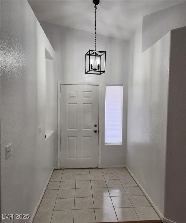 foyer featuring light tile patterned floors and a chandelier