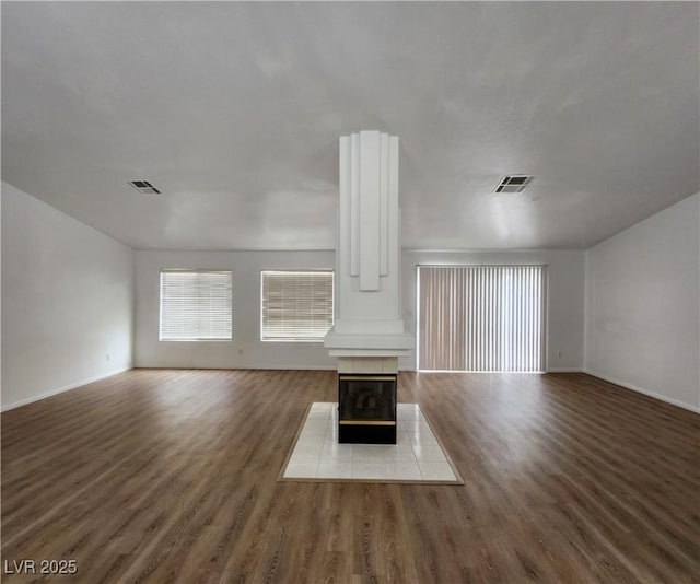 unfurnished living room featuring hardwood / wood-style floors and a tile fireplace