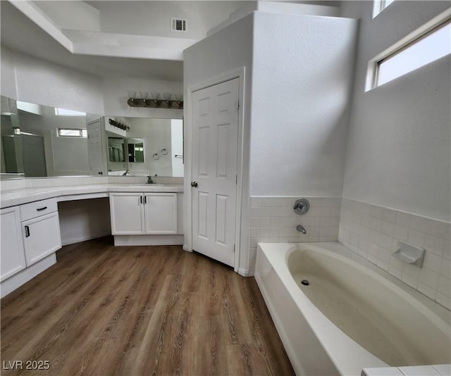 bathroom featuring hardwood / wood-style flooring, vanity, and a bathtub