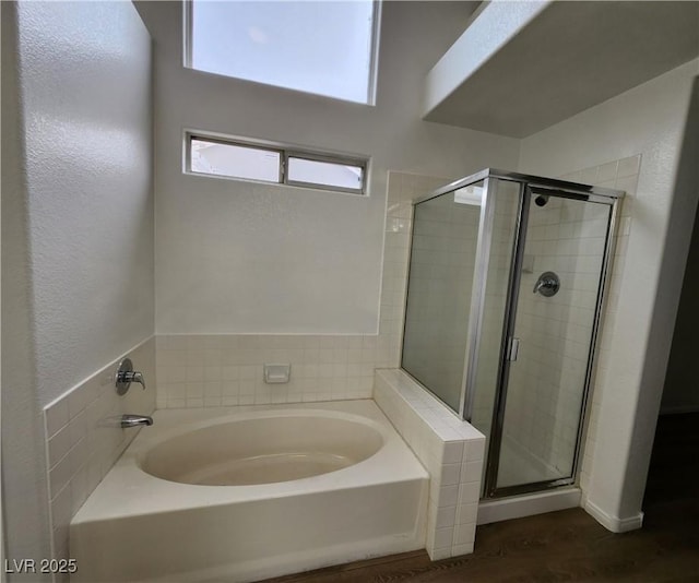 bathroom with hardwood / wood-style floors and separate shower and tub