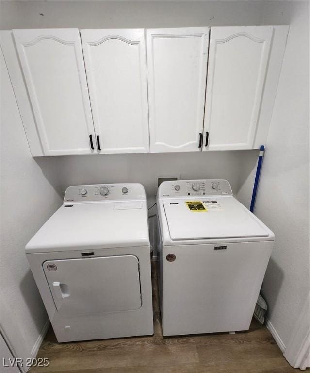 washroom featuring cabinets, hardwood / wood-style floors, and independent washer and dryer