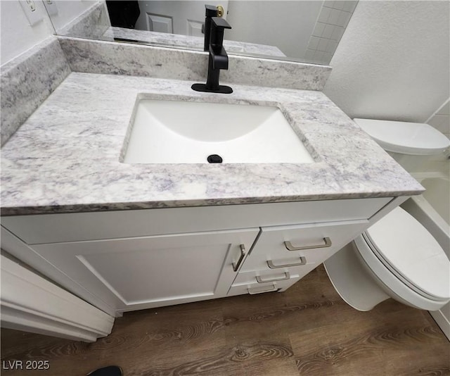 bathroom with vanity, hardwood / wood-style floors, and toilet