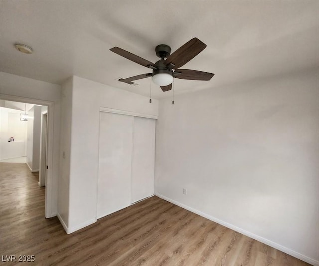 unfurnished bedroom with hardwood / wood-style flooring, ceiling fan, and a closet