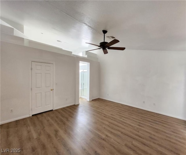 unfurnished room featuring vaulted ceiling, a textured ceiling, ceiling fan, and dark hardwood / wood-style flooring