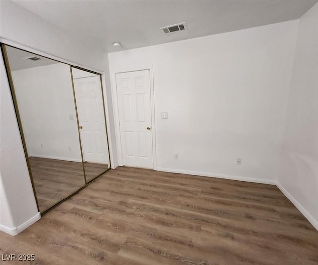 unfurnished bedroom with hardwood / wood-style floors and a closet