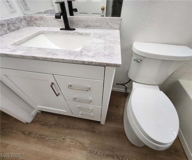 bathroom featuring vanity, toilet, and hardwood / wood-style floors