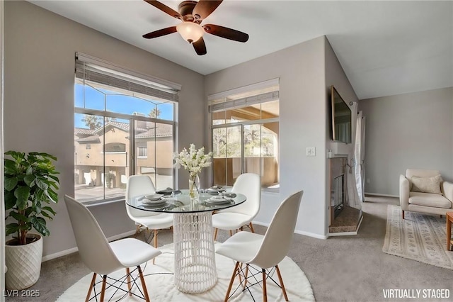 dining space featuring light carpet and ceiling fan