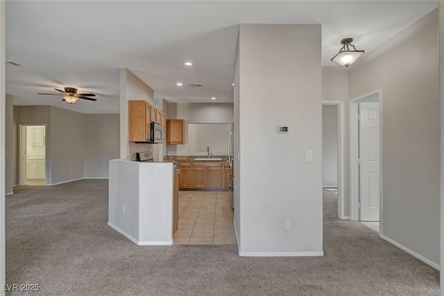 kitchen with ceiling fan, light colored carpet, and sink