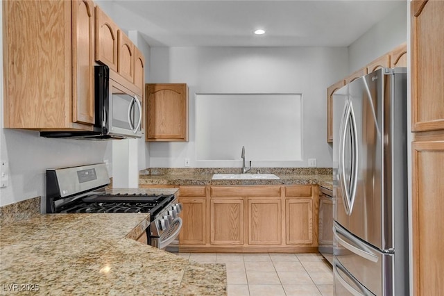 kitchen featuring appliances with stainless steel finishes, sink, light brown cabinets, and light tile patterned floors