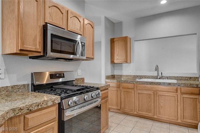 kitchen featuring light tile patterned flooring, stainless steel appliances, sink, and light brown cabinets