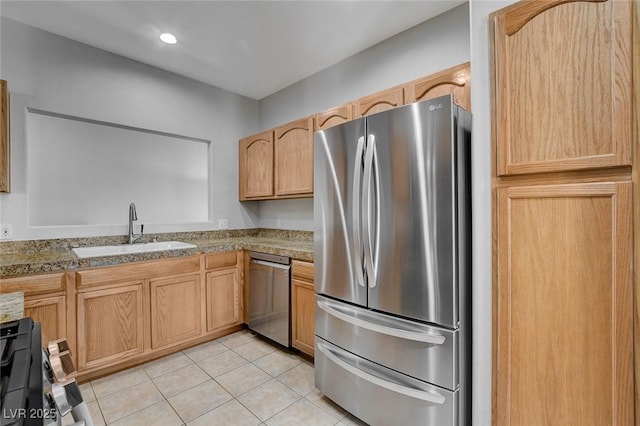 kitchen featuring light tile patterned flooring, appliances with stainless steel finishes, light brown cabinetry, and sink