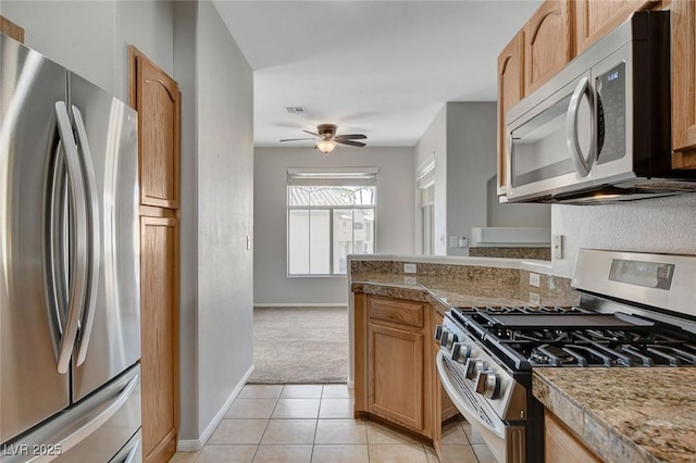 kitchen with light tile patterned flooring, ceiling fan, and appliances with stainless steel finishes