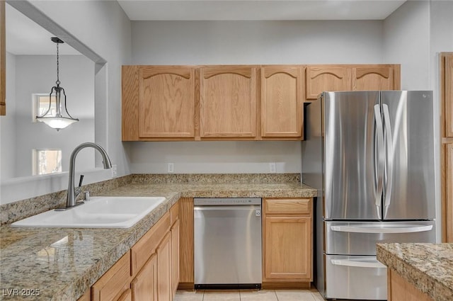 kitchen featuring appliances with stainless steel finishes, light brown cabinetry, and sink