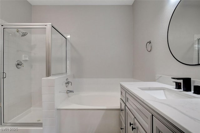 bathroom with vanity and shower with separate bathtub