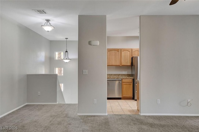 kitchen featuring light brown cabinetry, decorative light fixtures, light carpet, appliances with stainless steel finishes, and ceiling fan