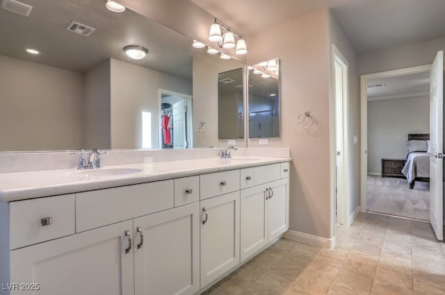 ensuite bathroom featuring double vanity, visible vents, and a sink