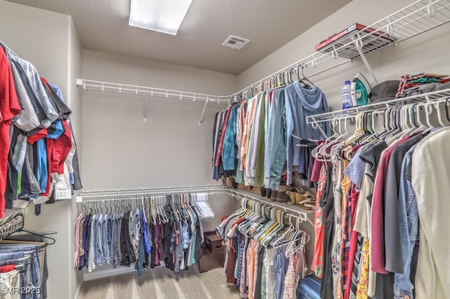 walk in closet featuring visible vents and carpet floors