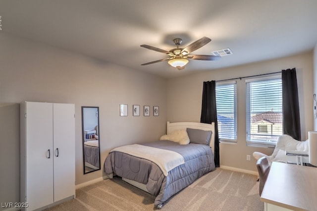 bedroom with visible vents, light carpet, baseboards, and ceiling fan