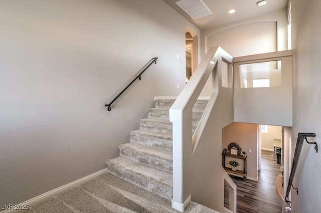 staircase featuring arched walkways, visible vents, recessed lighting, and baseboards