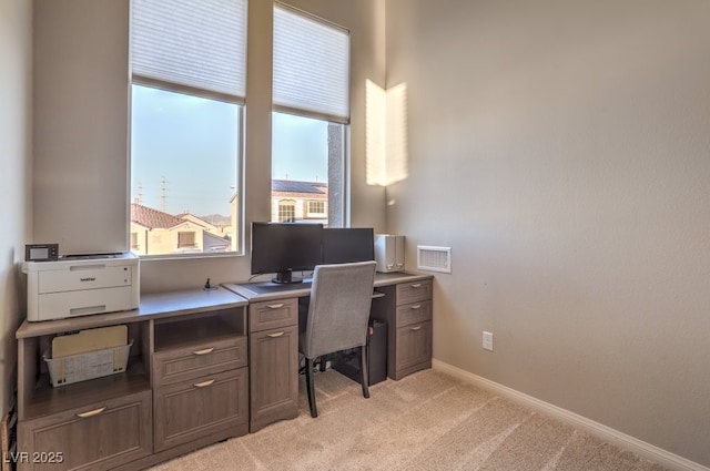 office area featuring light colored carpet and baseboards