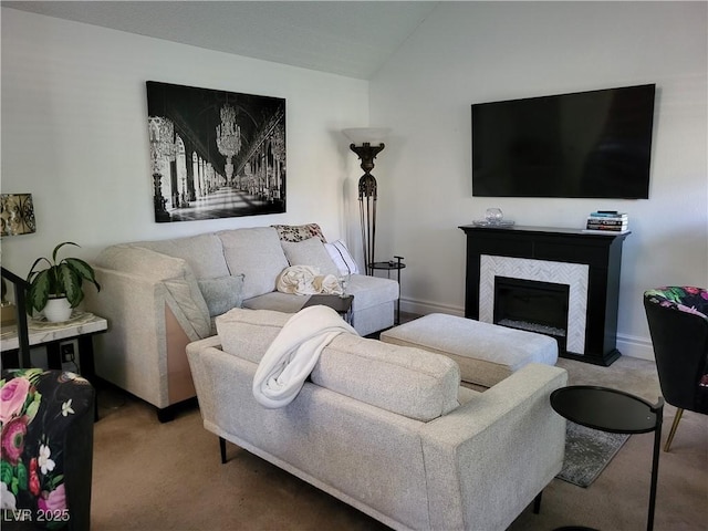 living room with carpet flooring, a tiled fireplace, and vaulted ceiling