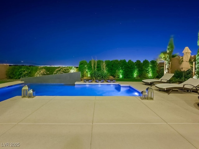 pool at twilight with a patio area