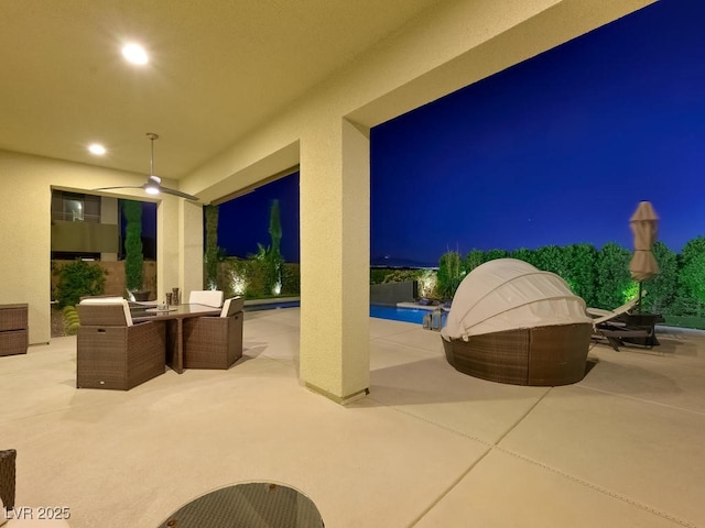 patio at twilight with ceiling fan and an outdoor hangout area